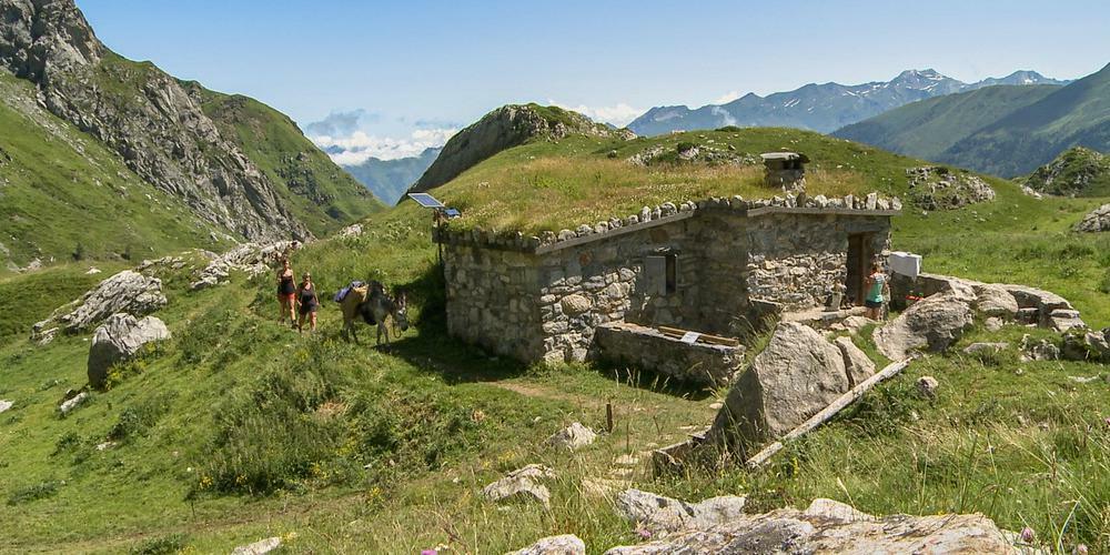 Guide racontant lhistoire dune bergerie daltitude à un groupe de randonneurs