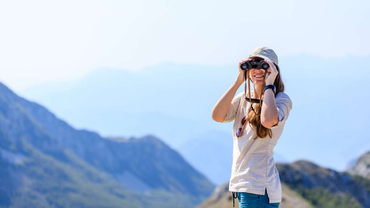 Randonneuse observant des oiseaux en montagne